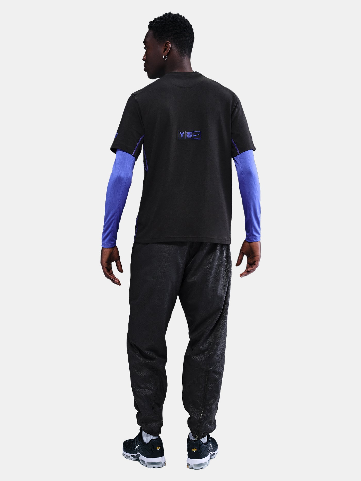 Black FC Barcelona T-shirt with blue Kobe Bryant logo on the chest, paired with black shorts featuring the same emblem.