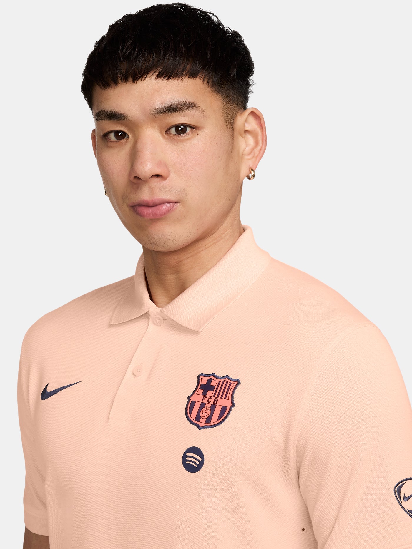 FC Barcelona light peach polo shirt with collar, featuring the club crest and Spotify logo on the chest alongside the Nike swoosh in navy