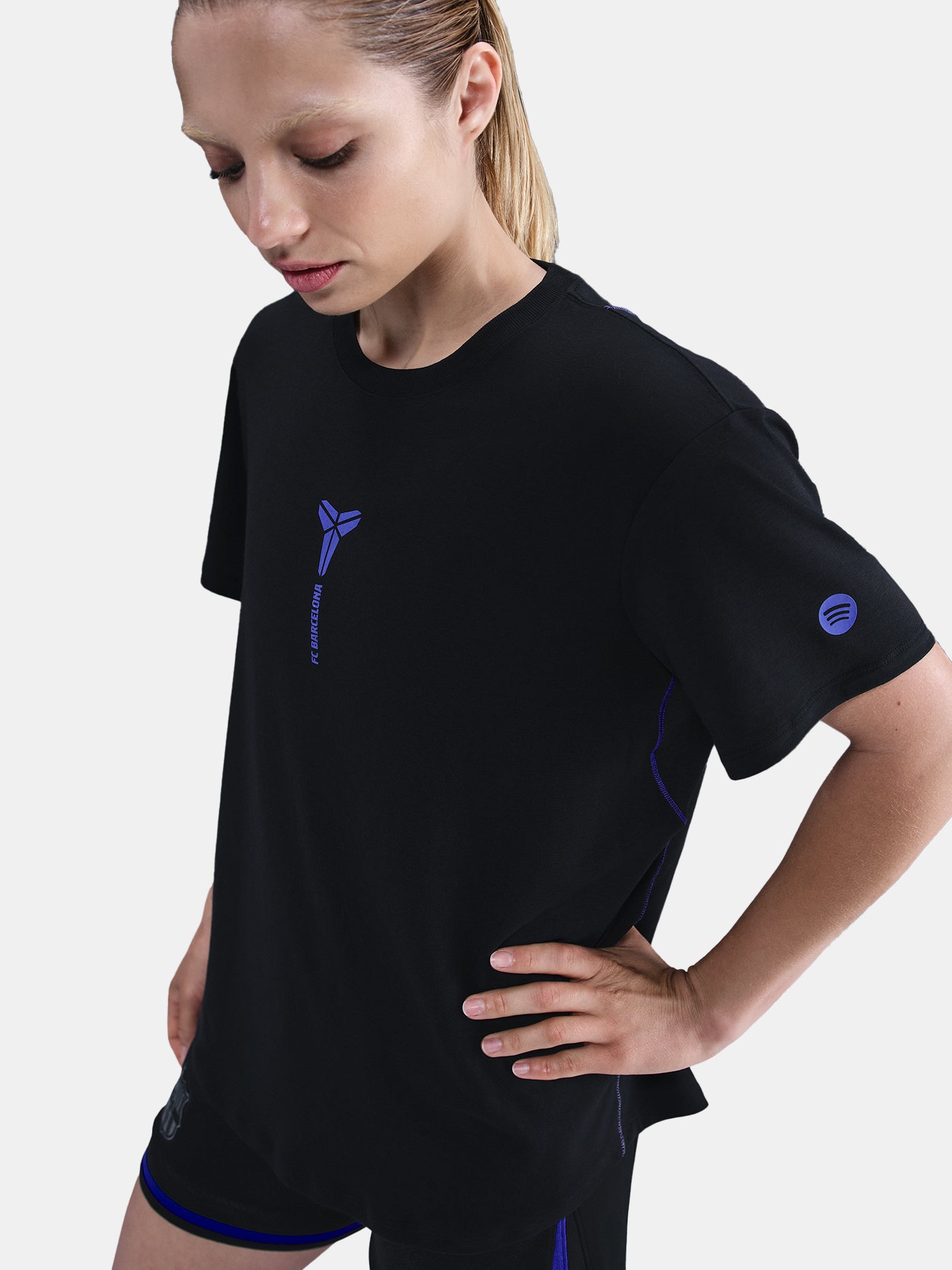 Black FC Barcelona T-shirt with blue Kobe Bryant logo on the chest, paired with black shorts featuring the same emblem.