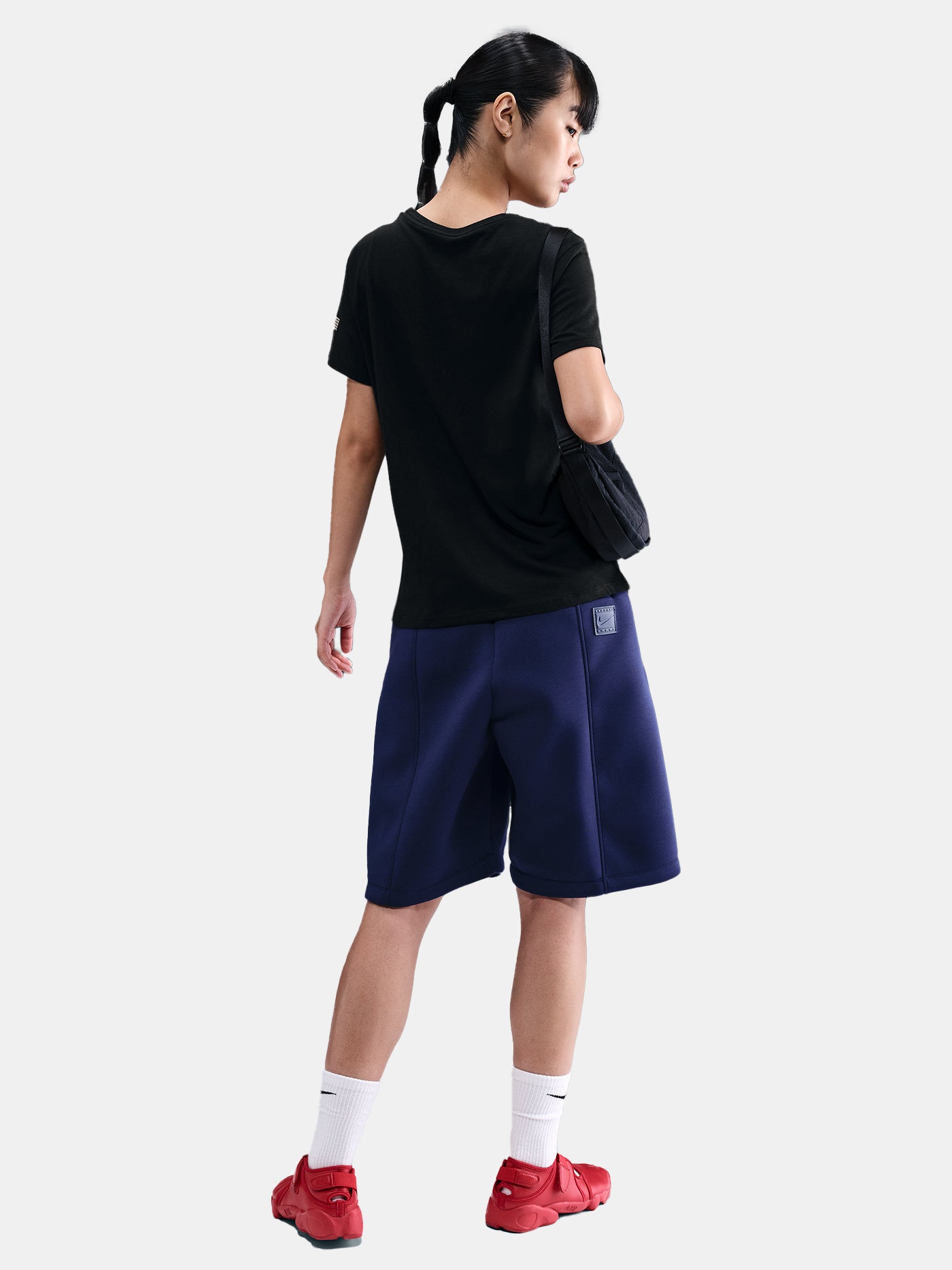 Black FC Barcelona Nike t-shirt with blue Barça crest on the chest, worn casually with blue pants and a black shoulder bag