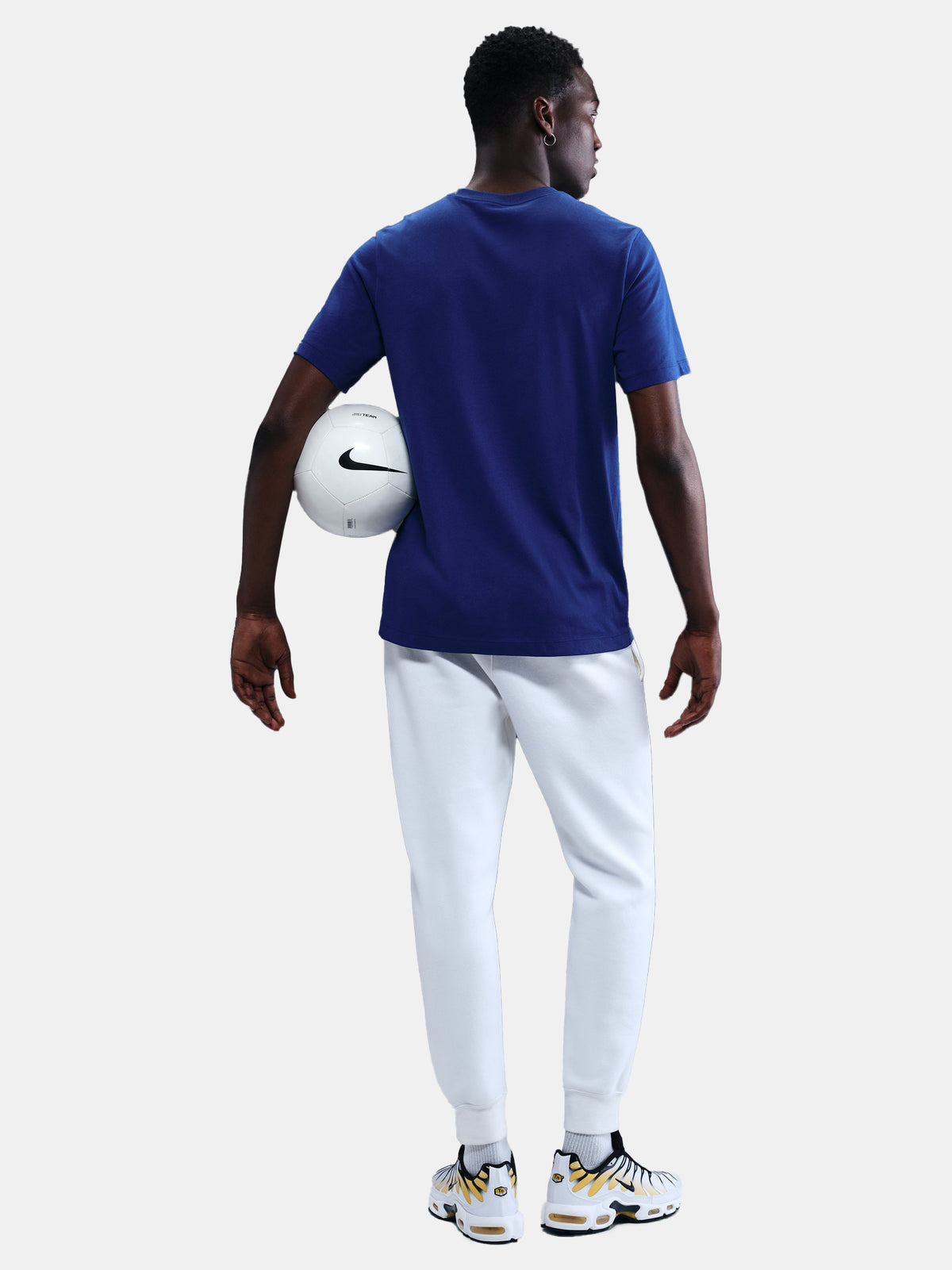 FC Barcelona men's t-shirt in royal blue featuring a minimalist front graphic with the Catalan and club colors, accompanied by the Nike Swoosh and Barça’s “Més que un club” symbol underneath. The design offers a clean and athletic streetwear look, perfect for everyday wear or matchday style.
