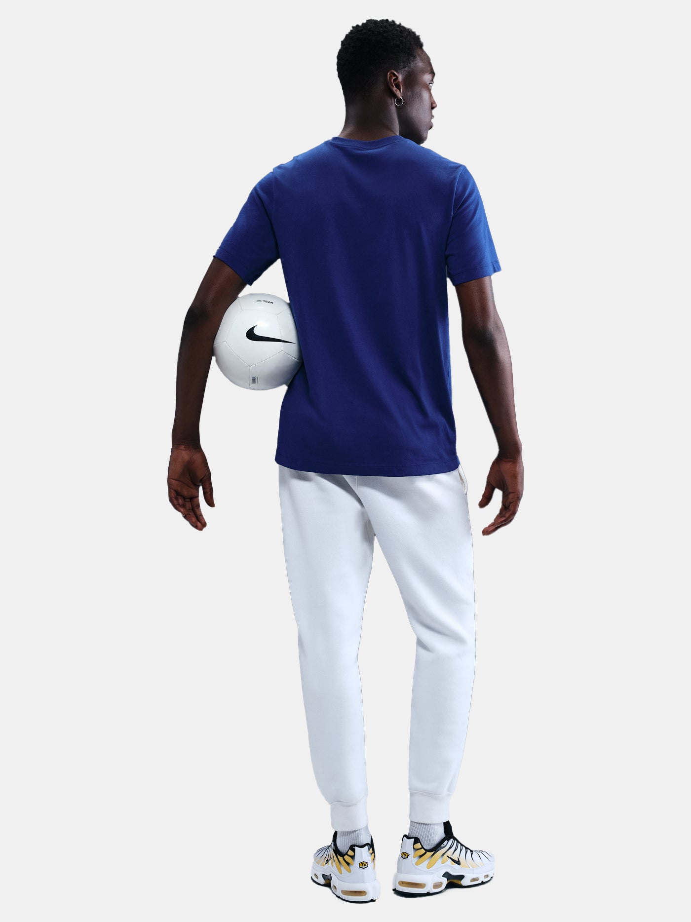 FC Barcelona men's t-shirt in royal blue featuring a minimalist front graphic with the Catalan and club colors, accompanied by the Nike Swoosh and Barça’s “Més que un club” symbol underneath. The design offers a clean and athletic streetwear look, perfect for everyday wear or matchday style.
