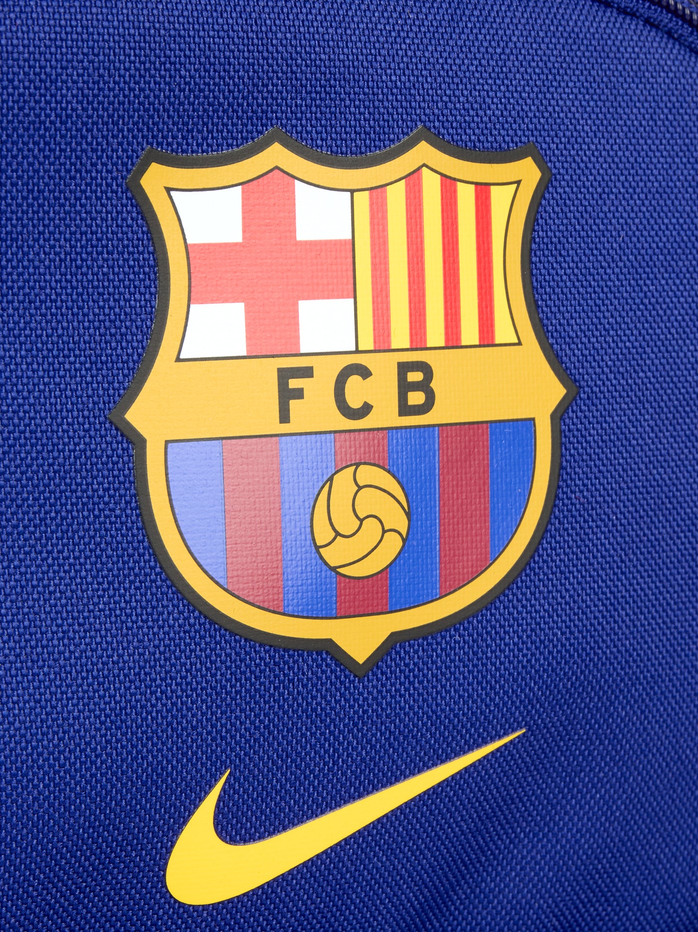 Mini FC Barcelona backpack in bold royal blue, featuring the Barça crest and yellow Nike swoosh on the front. Includes a front zip pocket, side mesh compartments, and a top handle. Finished with a black “JUST DO IT.” tag for a sporty touch.
