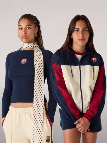 Models wearing Barça clothing from the lifestyle collection in navy, cream and red tones.