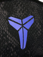 Small black FC Barcelona Nike backpack with textured upper panel, featuring the Kobe Bryant logo in blue on the front, the Barça crest with Nike swoosh in blue on the lower pocket, and a side tag reading 'Just Do It