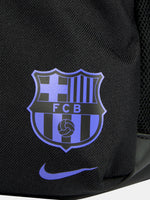 Small black FC Barcelona Nike backpack with textured upper panel, featuring the Kobe Bryant logo in blue on the front, the Barça crest with Nike swoosh in blue on the lower pocket, and a side tag reading 'Just Do It