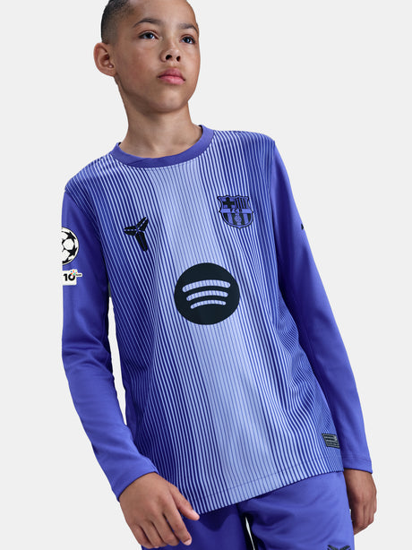 Child wearing a blue sports jersey with various logos on a white background