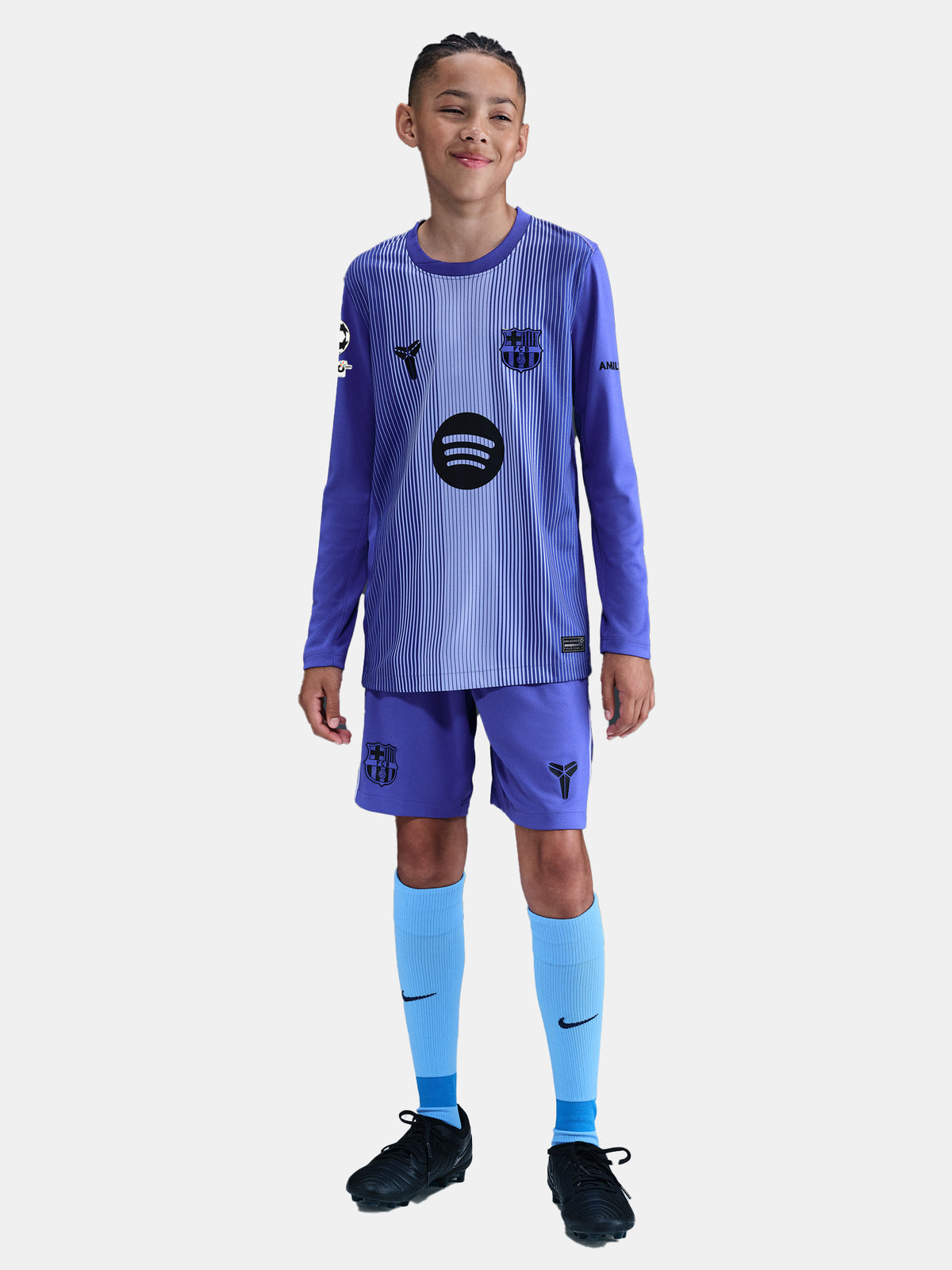 Child wearing a blue sports uniform with visible branding on a white background