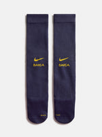 Parell de mitjons blau marí del FC Barcelona amb el swoosh groc de Nike i el logotip de BARÇA, mostrats un al costat de l’altre sobre fons blanc.