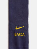 Primer pla d’un mitjó blau marí de FC Barcelona amb el swoosh groc de Nike i el text BARCA.