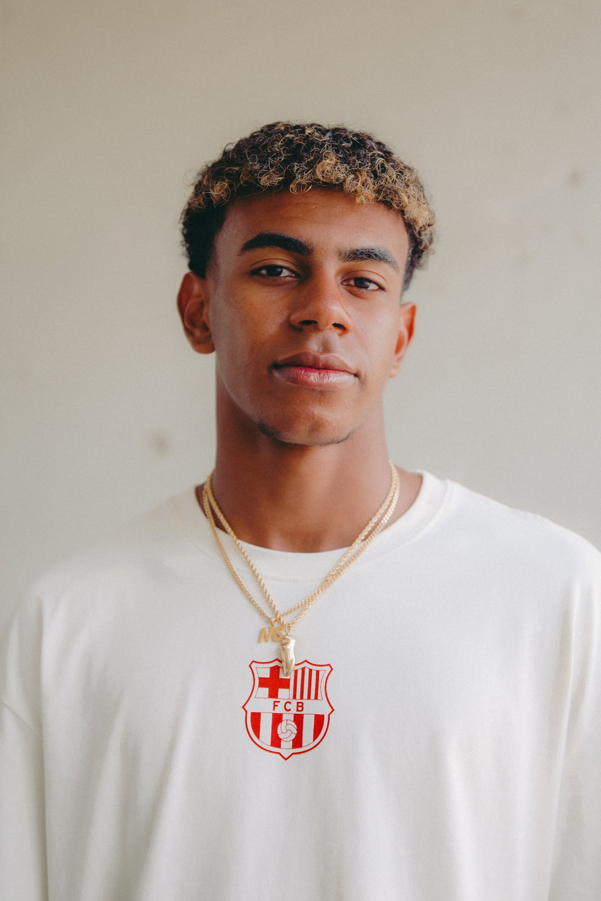 off-white FC Barcelona T-shirt with 'MÉS QUE UN CLUB' and '1899' printed on the back in red and blue,