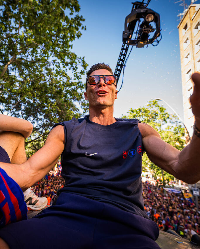 Man in sports jersey surrounded by people with a cityscape in the background