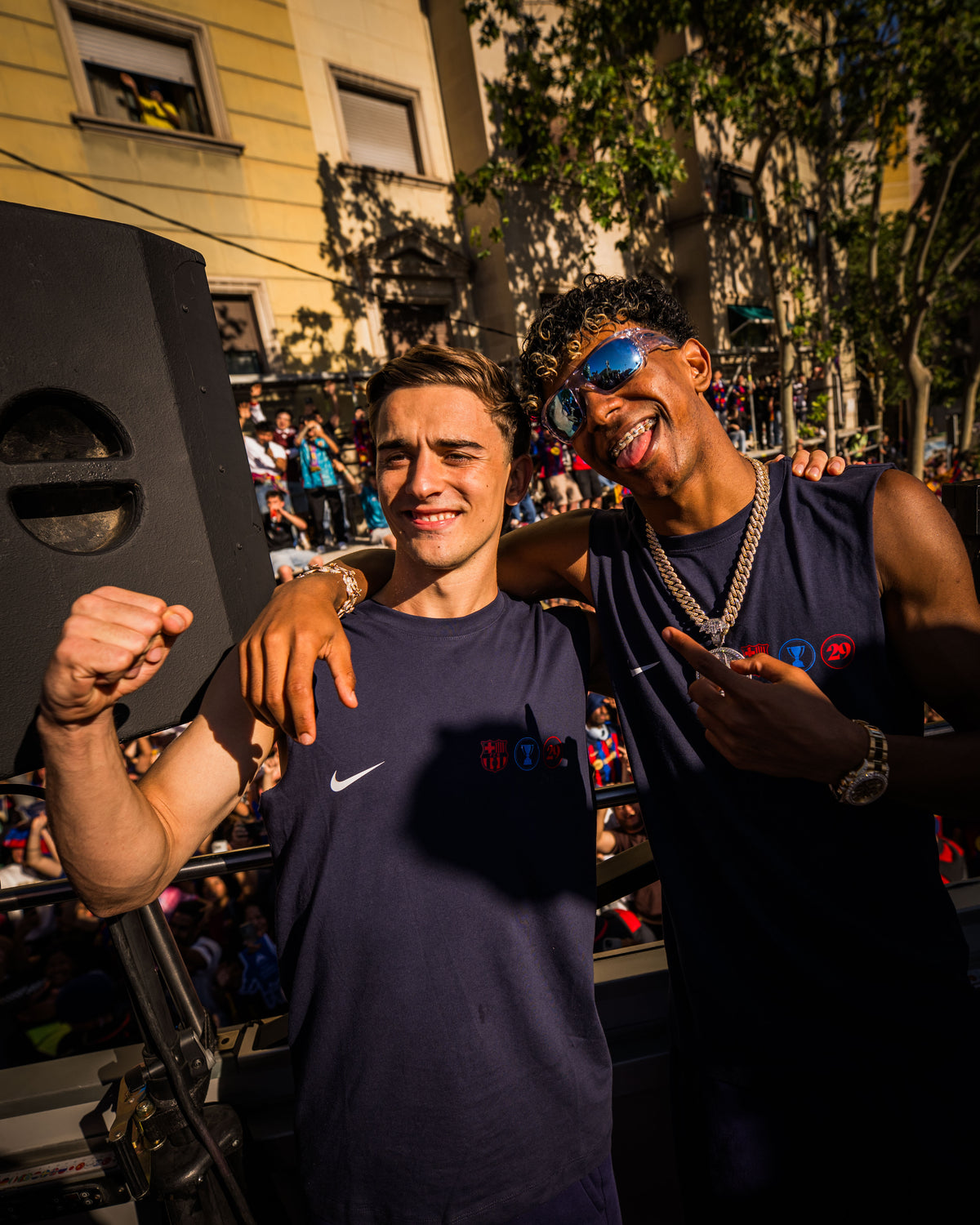 Two people posing together in a festive outdoor setting with music equipment.