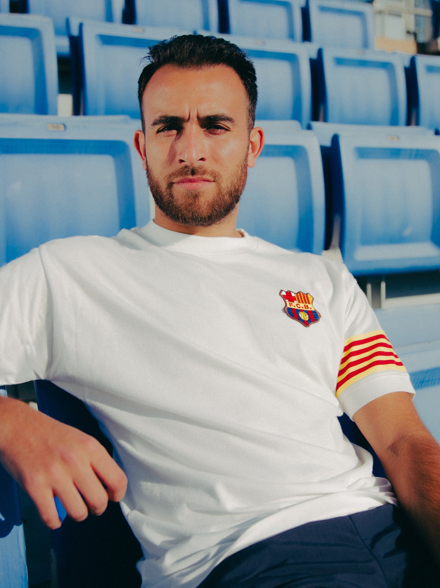 White T-shirt with FC Barcelona crest on the chest, Catalan flag detail on the sleeve, and red number 9 on the back.