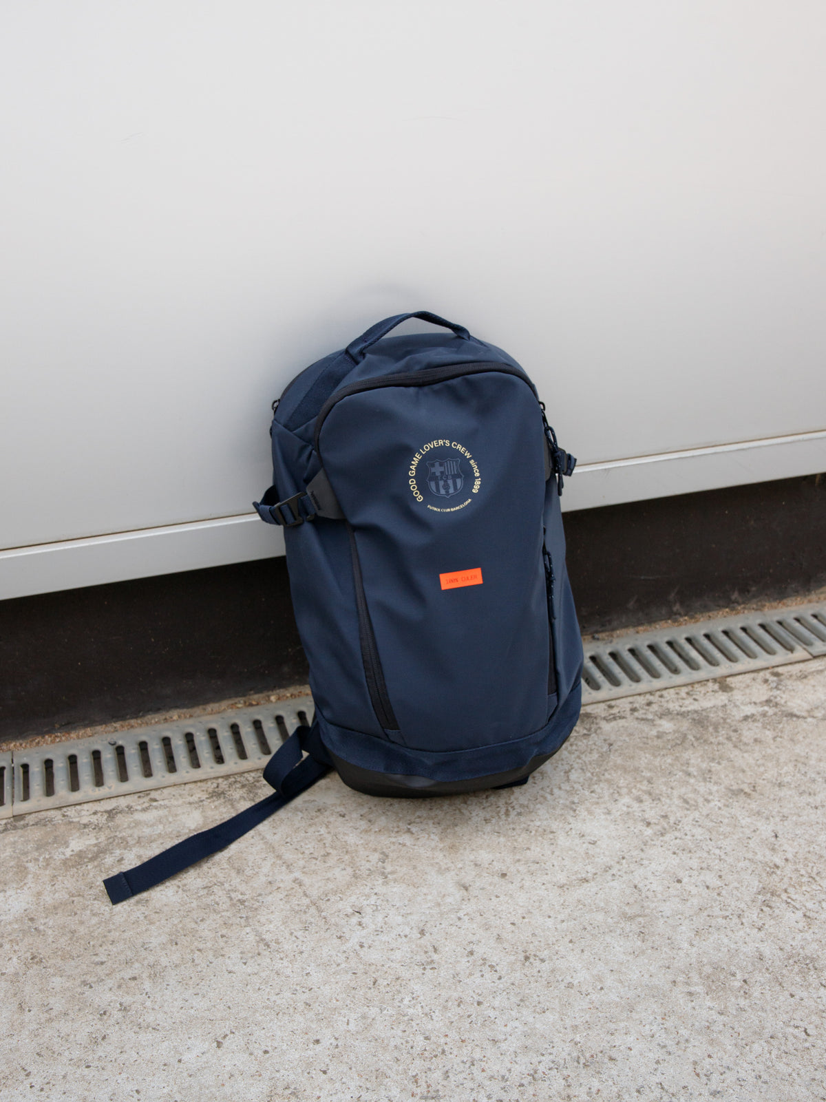 Navy FC Barcelona backpack with embroidered circular crest design, side pocket, and red '1899' patch on the front