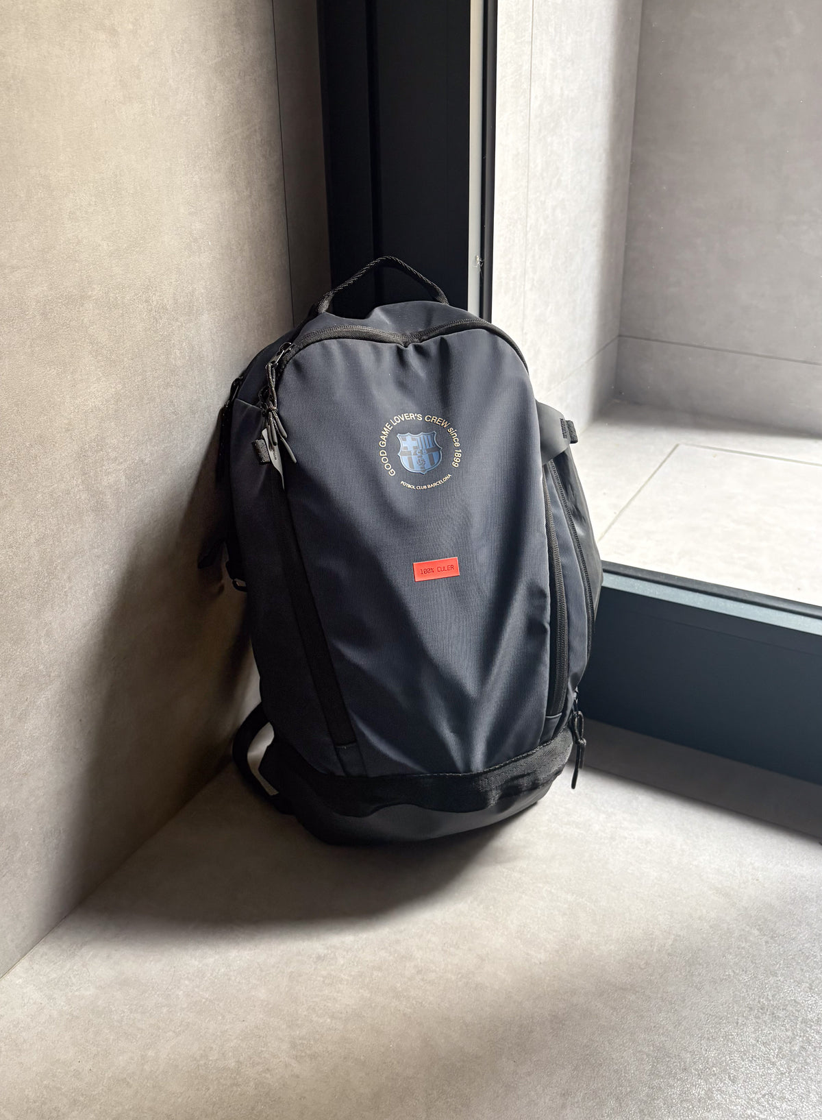 Navy FC Barcelona backpack with embroidered circular crest design, side pocket, and red '1899' patch on the front