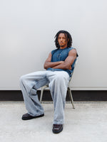 Jules Kounde wearing a sleeveless dark blue FC Barcelona T-shirt with circular crest print on the chest, paired with light denim jeans