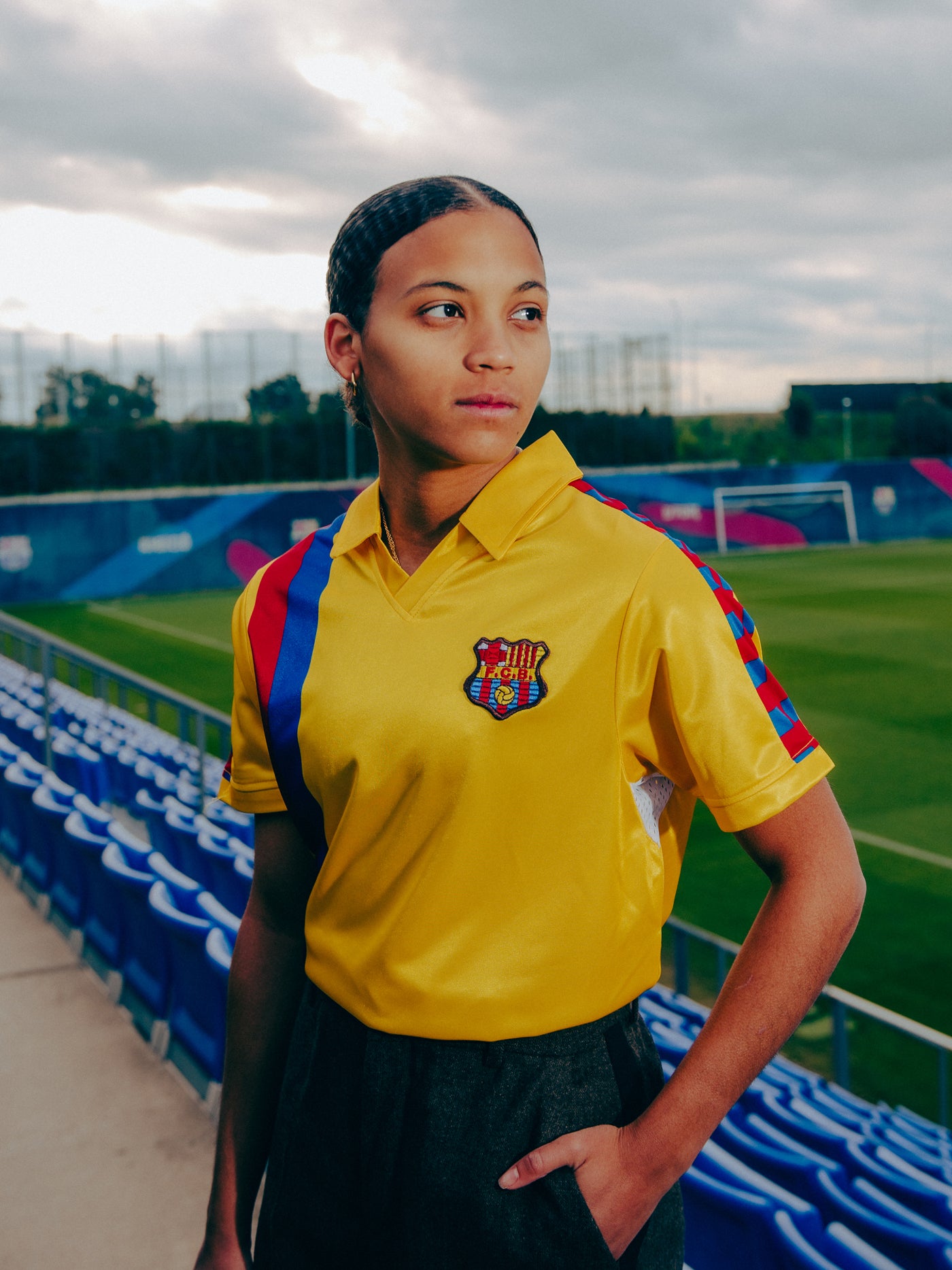 Yellow short-sleeve polo shirt with FC Barcelona crest and vertical red and blue stripe design.