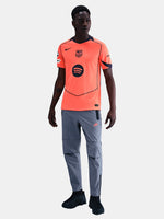 FC Barcelona third kit football jersey in orange with navy blue details, featuring Spotify sponsor logo and Nike branding.