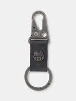 Black FC Barcelona keychain with metallic clasp, leather strap, and embossed club crest