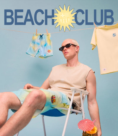 Two people sitting on beach chairs with a 'Beach Club' sign in the background.