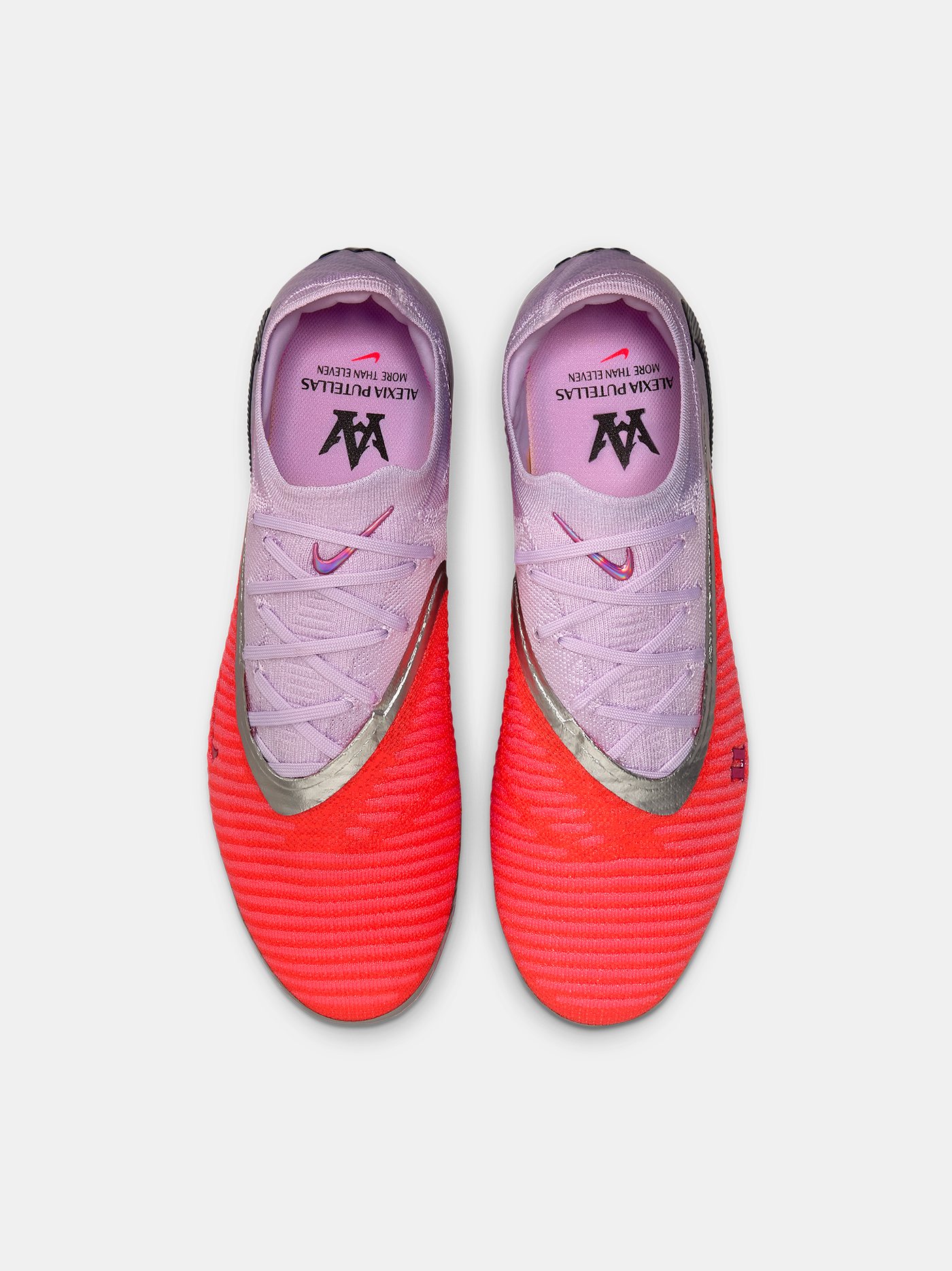 Pair of pink and red soccer cleats on a white background