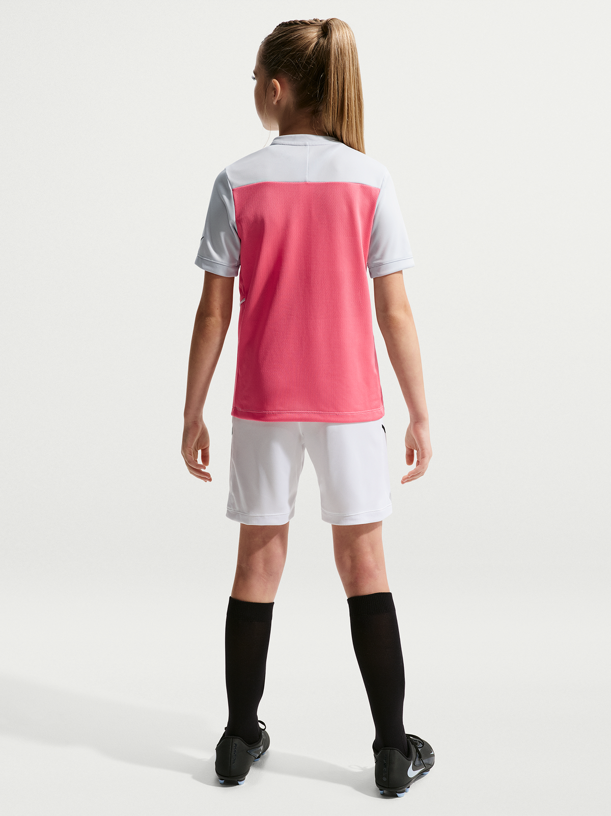 Person wearing a pink and white sports outfit on a white background