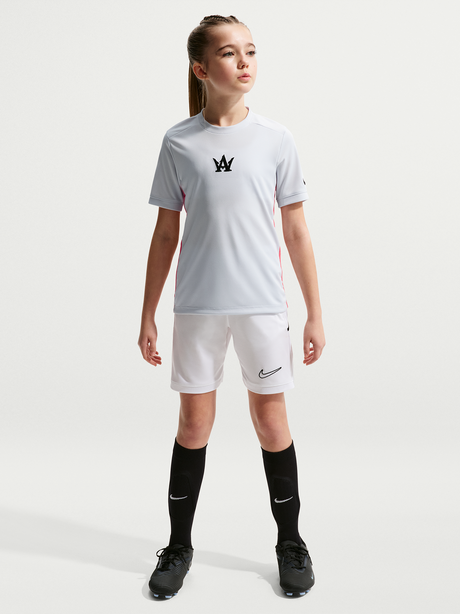 Young girl wearing a white sports outfit with a logo on a white background