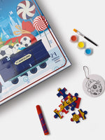 Boîte calendrier de l’Avent FC Barcelona avec bonbons et graphiques de football, montrée avec un pinceau, des pots de peinture, des pièces de puzzle et un ornement rond pour porte-clés.