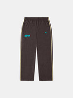 Pantalón de chándal marrón con estampado de leopardo de FC Barcelona, con texto Barça en verde azulado, swoosh de Nike y franjas laterales claras.