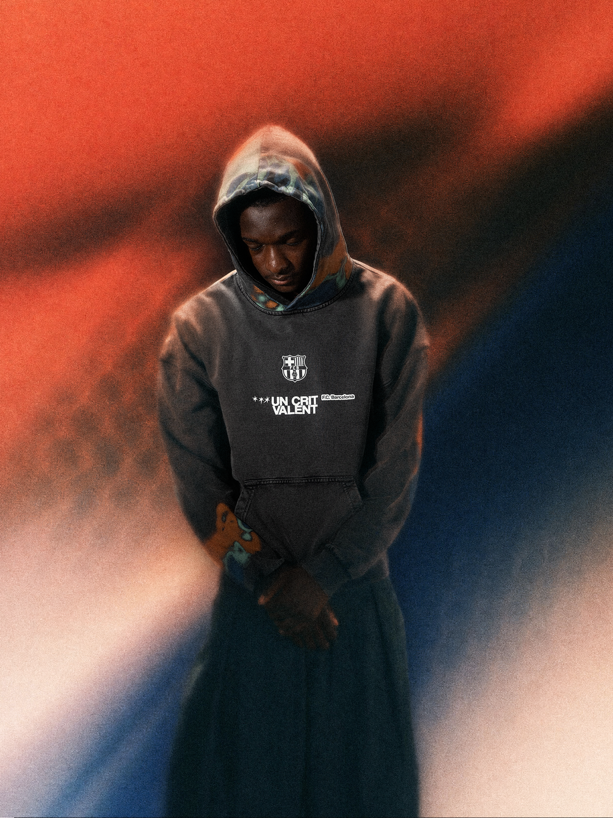 Mannequin portant un sweat à capuche sombre de FC Barcelona avec l’écusson du club et “UN CRIT VALENT” imprimés sur la poitrine.