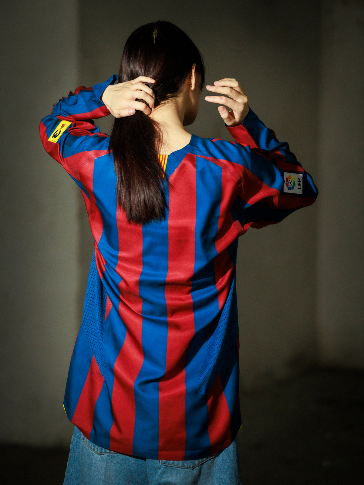 Person wearing a blue and red striped shirt with a blurred background