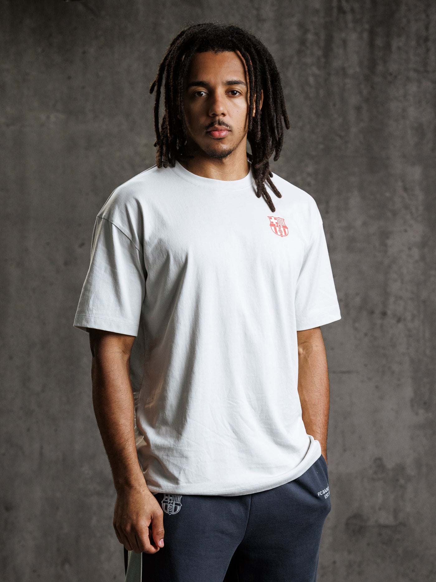 Man wearing a white t-shirt with a logo on a gray background