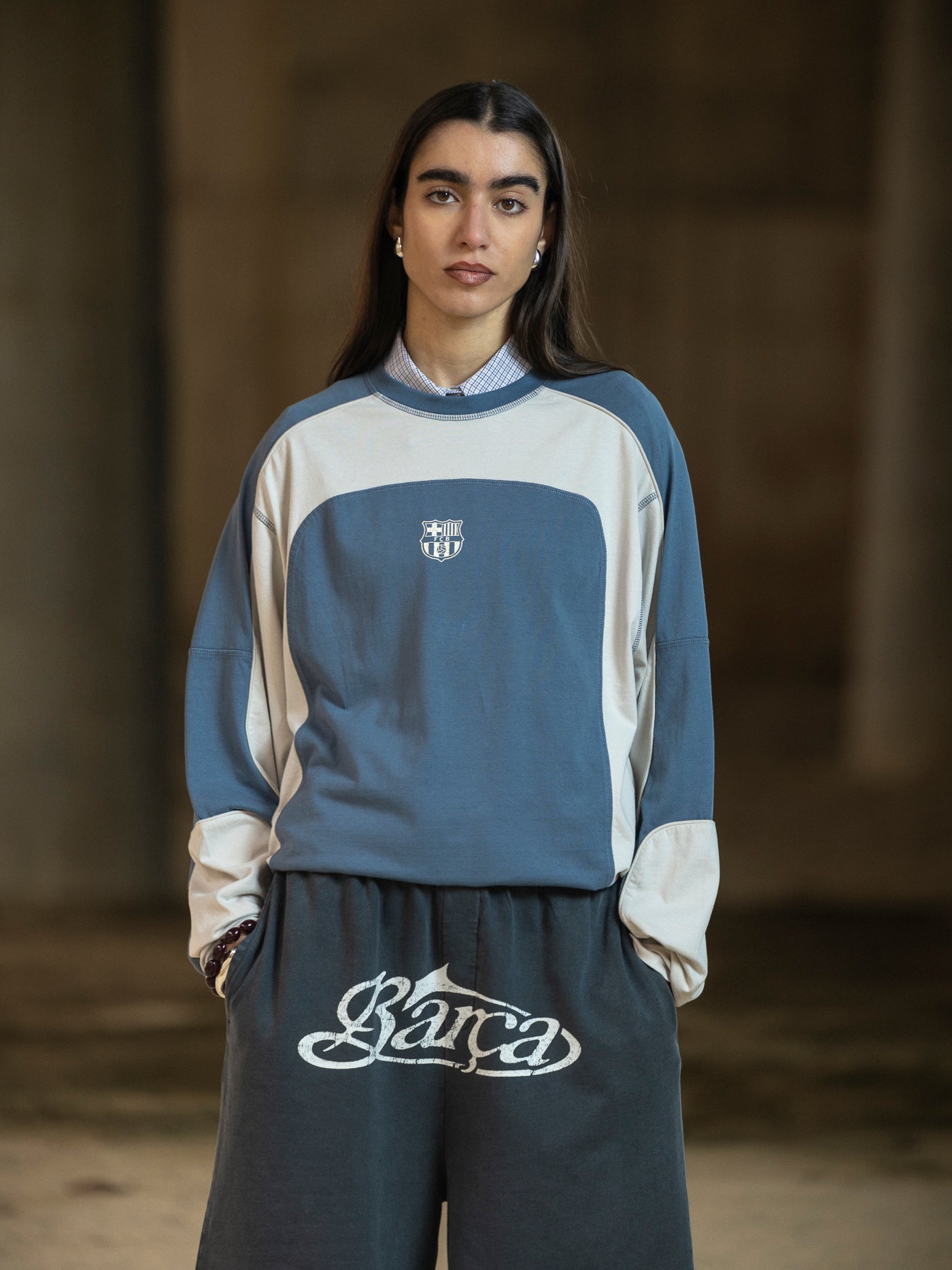 Person wearing a blue and beige tracksuit with a logo on a blurred background