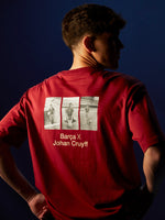 Person wearing a red T-shirt featuring three vintage photos of Johan Cruyff with a football, and the text 'Barça X Johan Cruyff' printed on the back