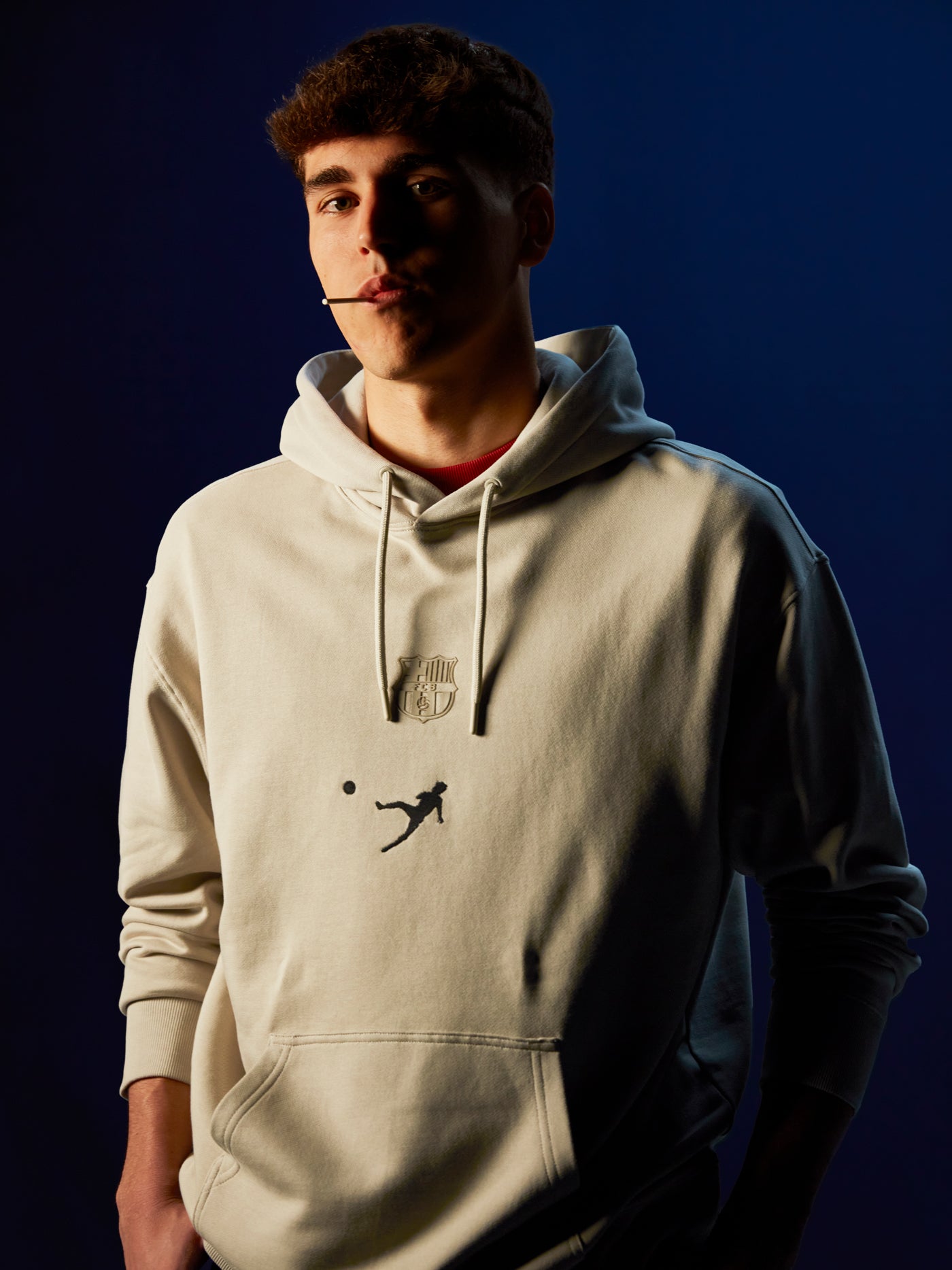 White FC Barcelona hoodie featuring the club's crest and a silhouette of Johan Cruyff performing a volley printed on the chest.