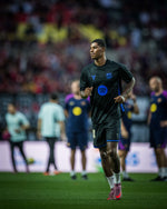 Marcus Rashford wearing a black FC Barcelona training kit with blue accents and Spotify sponsor logo during warm-up on the pitch