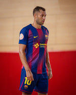 Man in FC Barcelona futsal kit with red and blue vertical stripes and number 10 on shorts