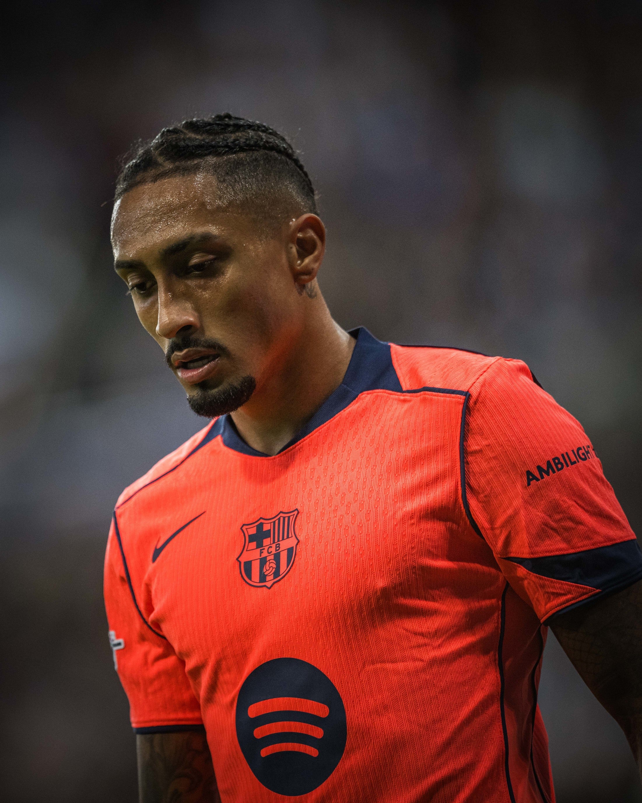 Raphinha wearing an orange jersey with a logo on a blurred background