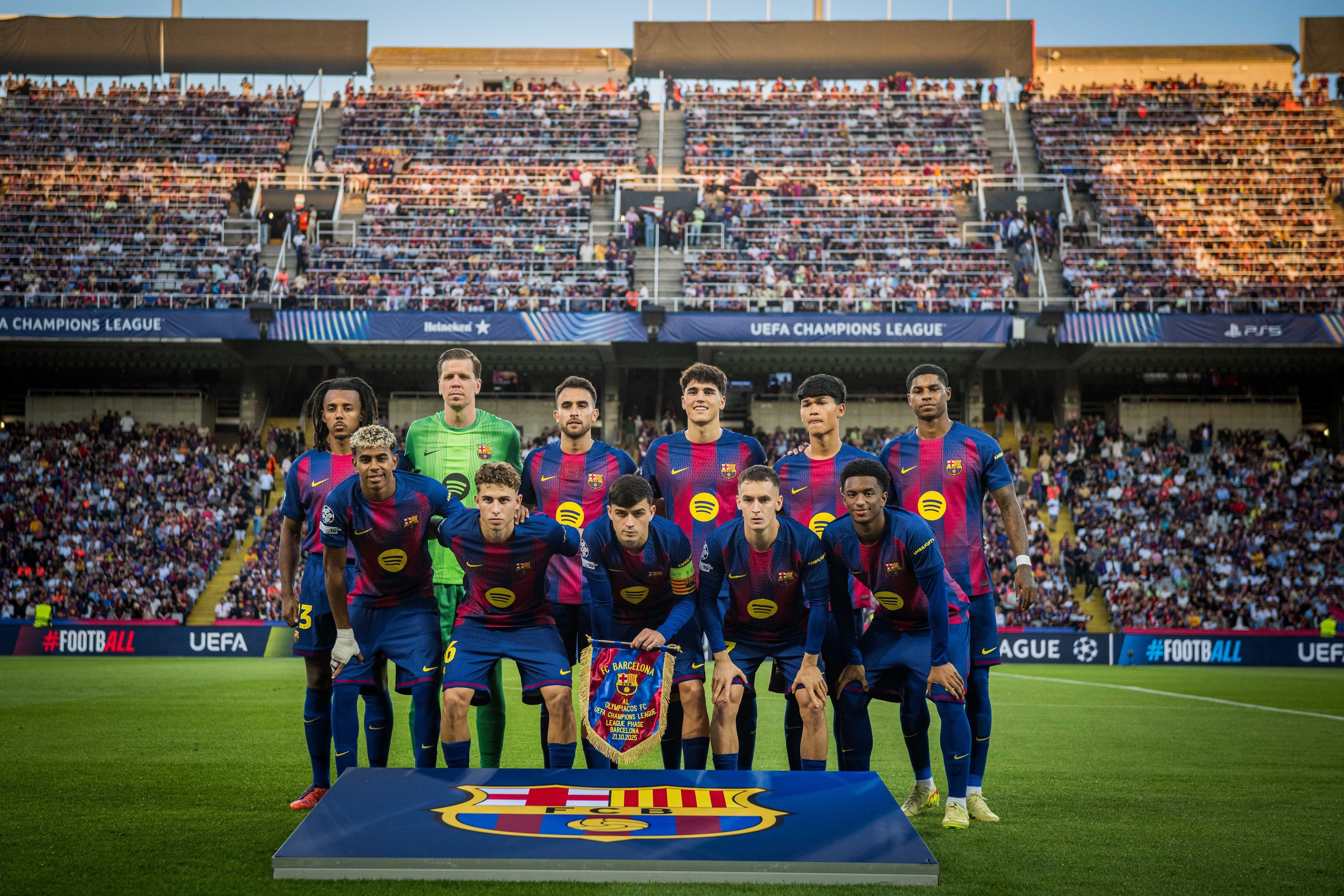 Soccer team posing with a trophy on a stadium field