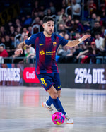 Soccer player in a match wearing a Barcelona jersey with a colorful ball.