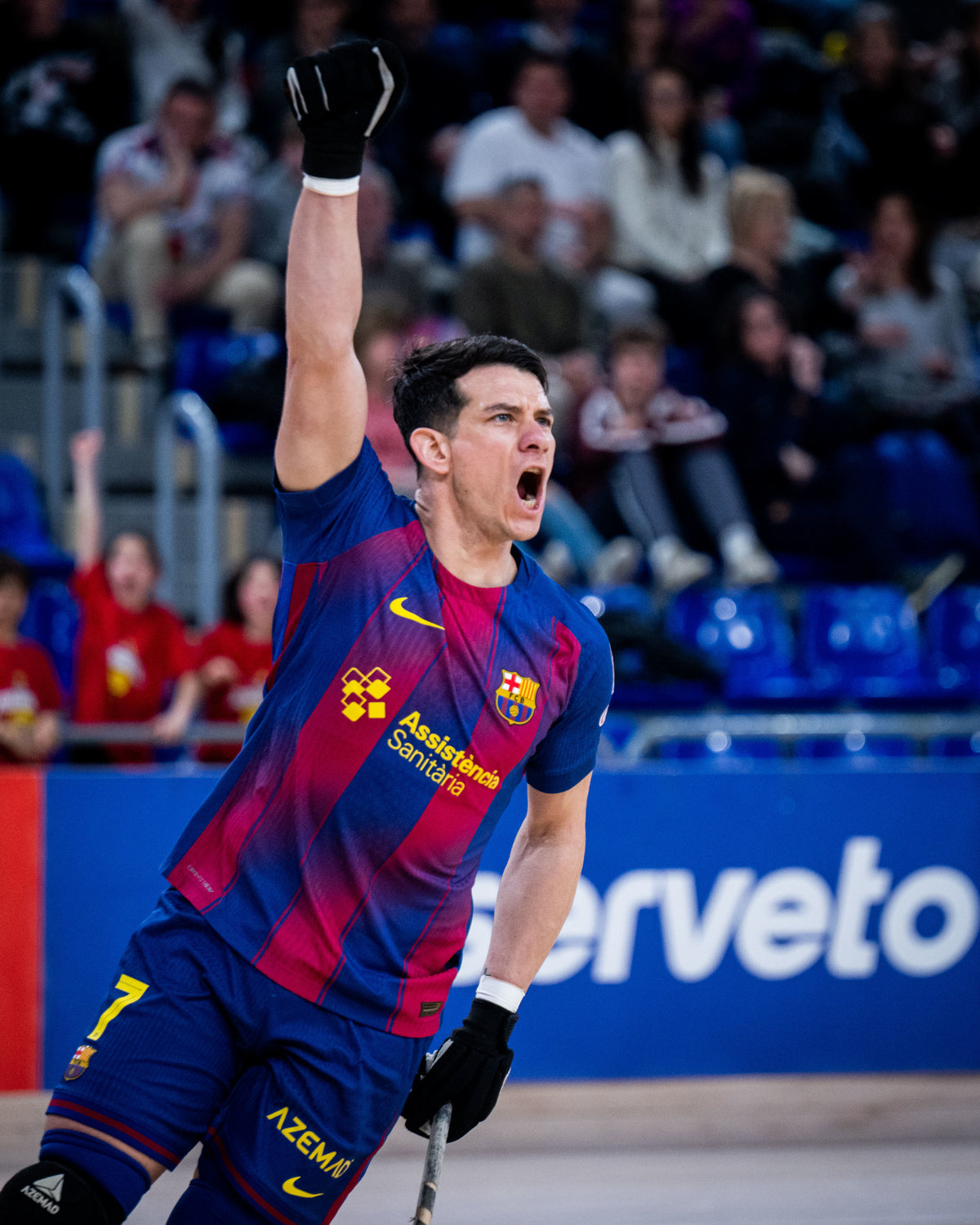 Person in a colorful sports jersey celebrating in front of an audience with  'Azena' branding.