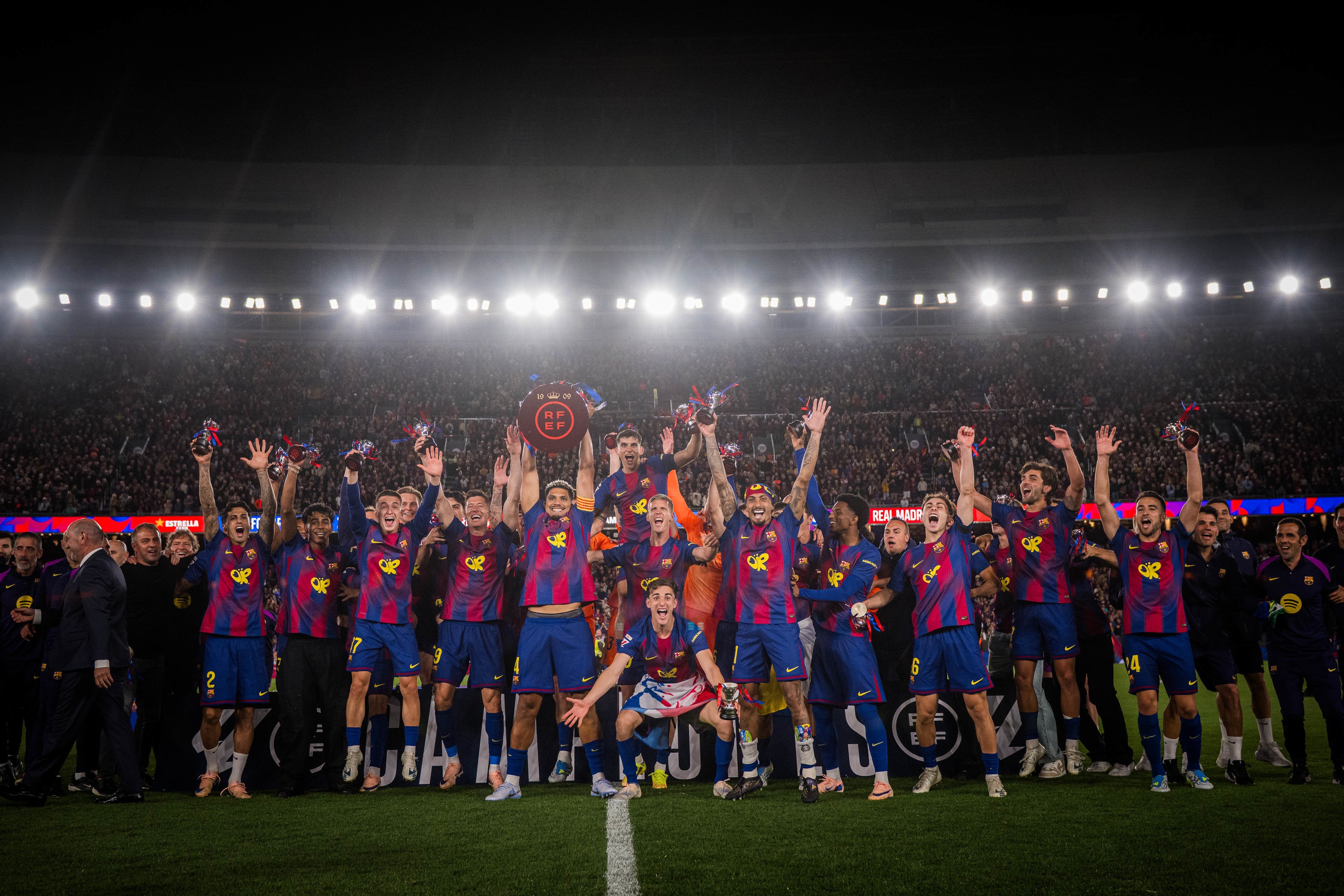 Futbol players celebrating with a trophy on a stadium