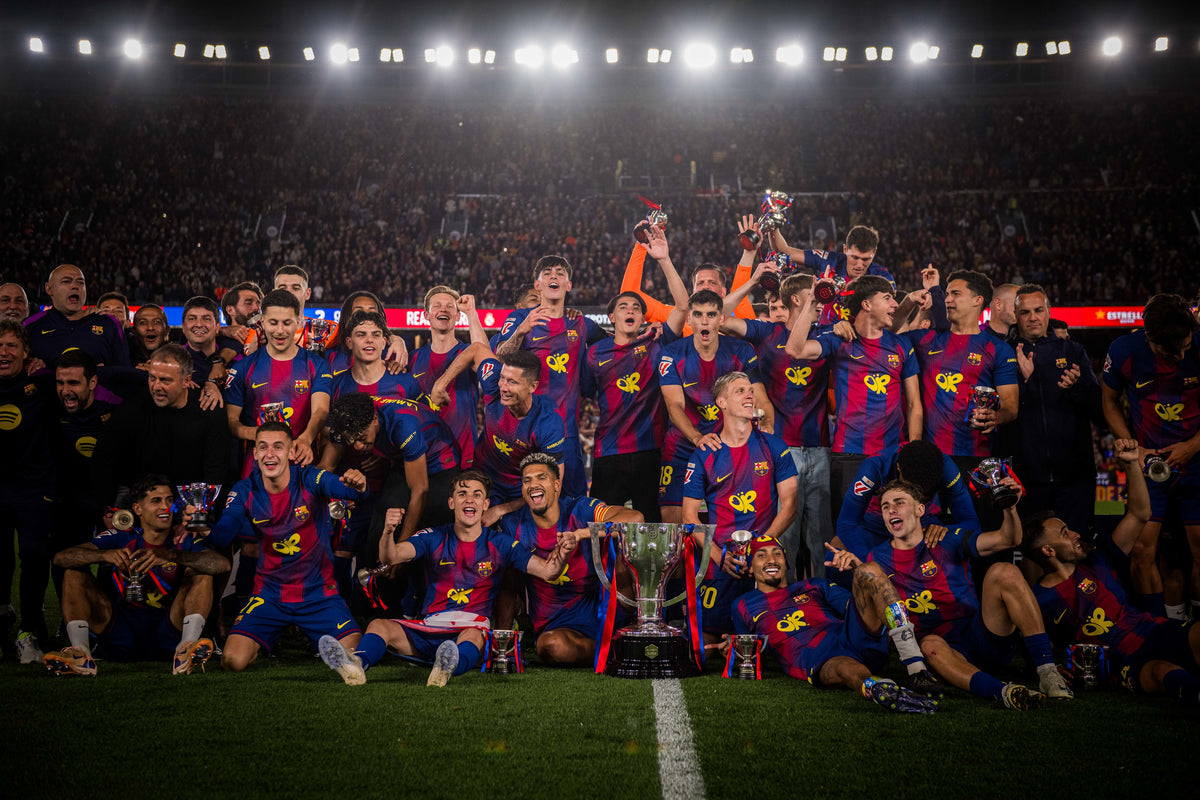 Futbol players celebrating with a trophy on a stadium