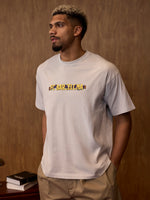 Man wearing a white t-shirt with 'FC BARCELONA' printed on it against a brown background