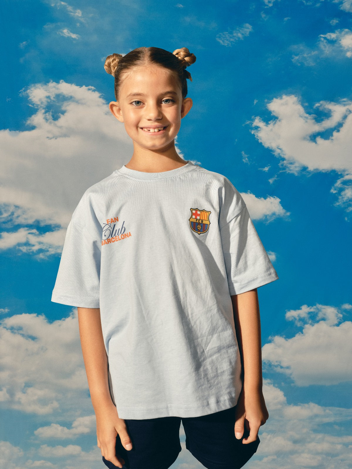 light grey FC Barcelona t-shirt with a large gradient club crest printed on the back, along with the text "Futbol Club Barcelona" and the motto "Tots units fem força
