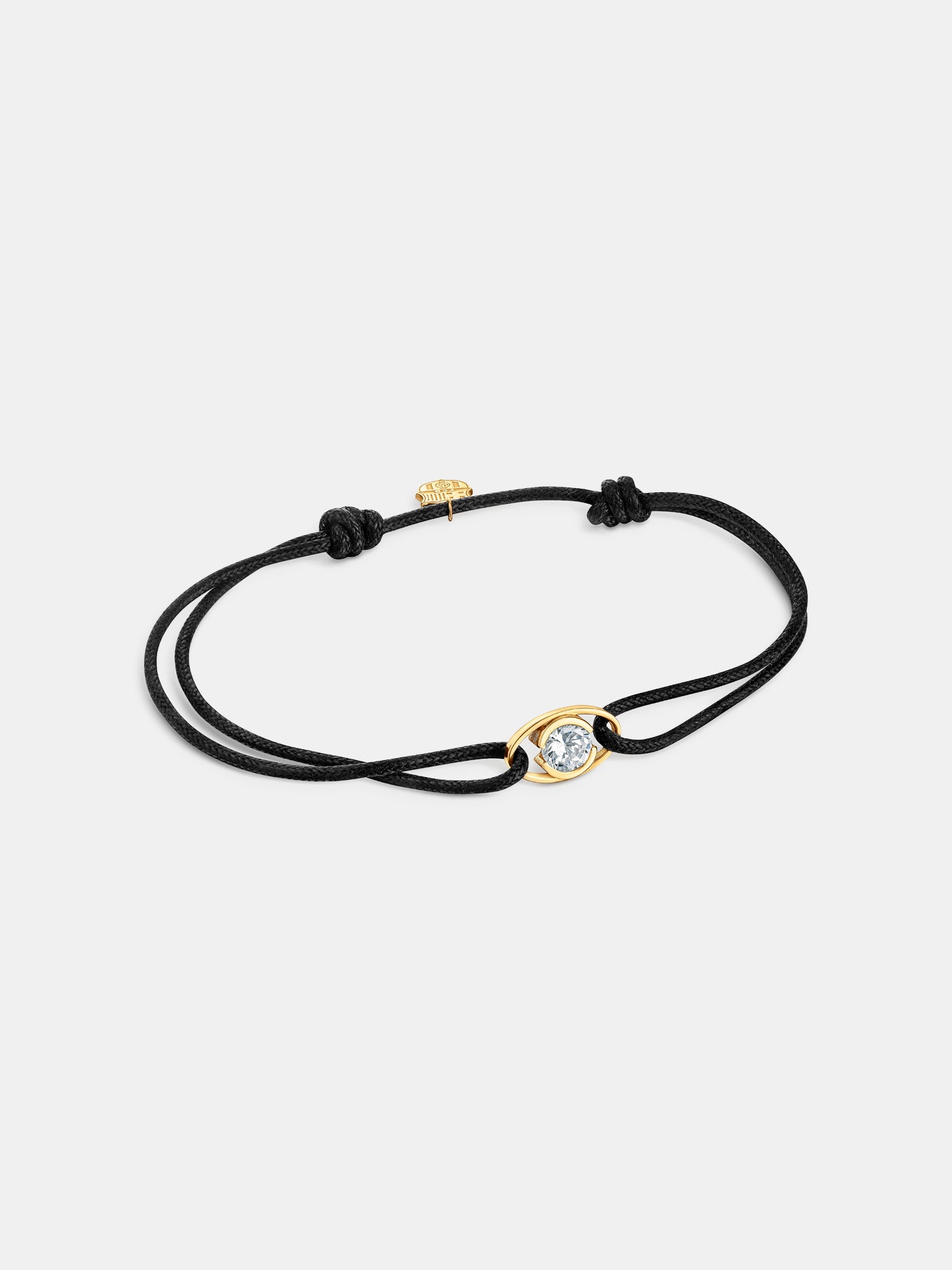 Black cord bracelet with a central gold eye-shaped charm featuring a diamond, and a small gold FC Barcelona logo charm.