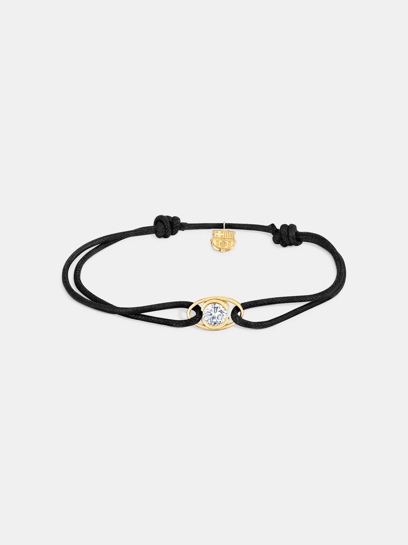 Black cord bracelet with a central gold eye-shaped charm featuring a diamond, and a small gold FC Barcelona logo charm.