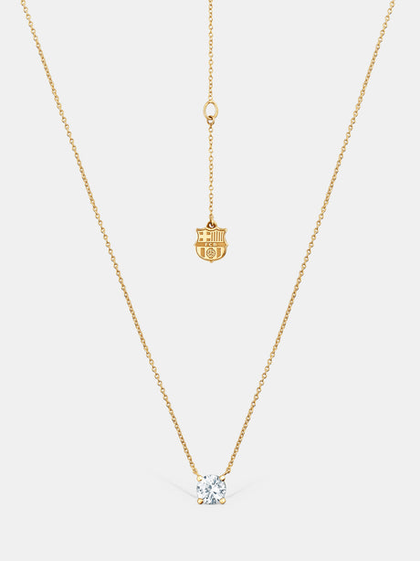 Elegant gold necklace featuring a central diamond-like stone and a small hanging FC Barcelona crest charm near the clasp.



