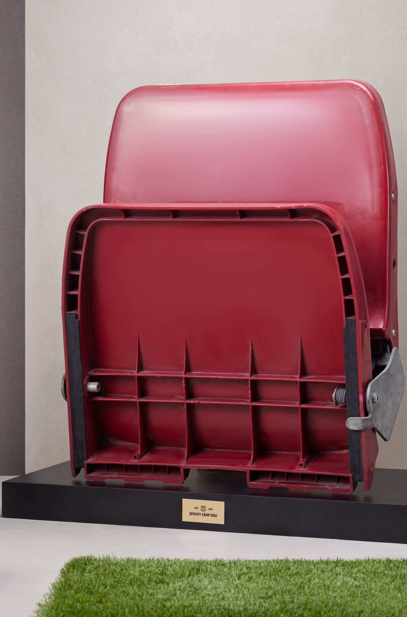 Original red stadium seat from Spotify Camp Nou mounted on a black display base with commemorative plaque.